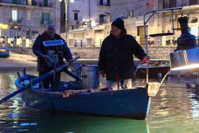 Una lampara per accecare i pesci e una fiocina per prenderli al volo: � l'antica "pesca a fuoco"  